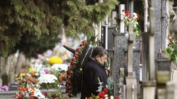 Un hombre ante una tumba en un cementerio