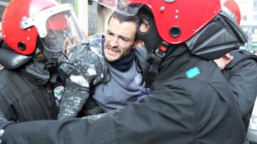 Un piquetero forcejea con agentes de la Ertzaintza en Bilbao