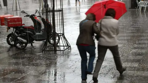 Dos mujeres se protegen con un paraguas de un chaparrón en Madrid Dos mujeres se protegen con un paraguas de un chaparrón en Madrid
