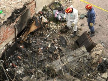 Dos bomberos de los equipos de extinción de incendios de Barcelona inspeccionan el solar de la calle Bilbao 134