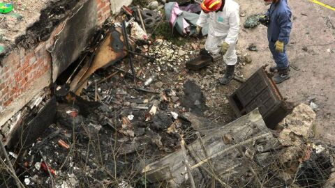 Dos bomberos de los equipos de extinci&oacute;n de incendios de Barcelona inspeccionan el solar de la calle Bilbao 134