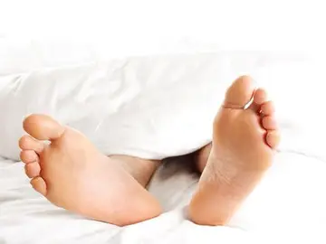 Un hombre descansa tumbado en una cama Un hombre descansa tumbado en una cama