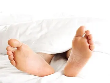 Un hombre descansa tumbado en una cama Un hombre descansa tumbado en una cama