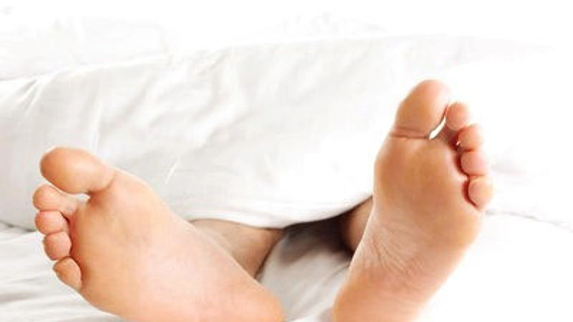 Un hombre descansa tumbado en una cama Un hombre descansa tumbado en una cama