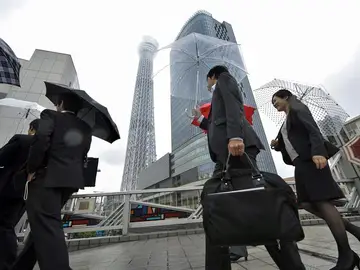 Japoneses que van a su trabajo con la torre de fondo Japoneses que van a su trabajo con la torre de fondo