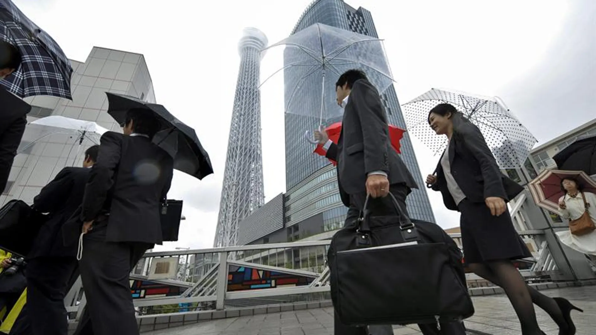 Japoneses que van a su trabajo con la torre de fondo Japoneses que van a su trabajo con la torre de fondo