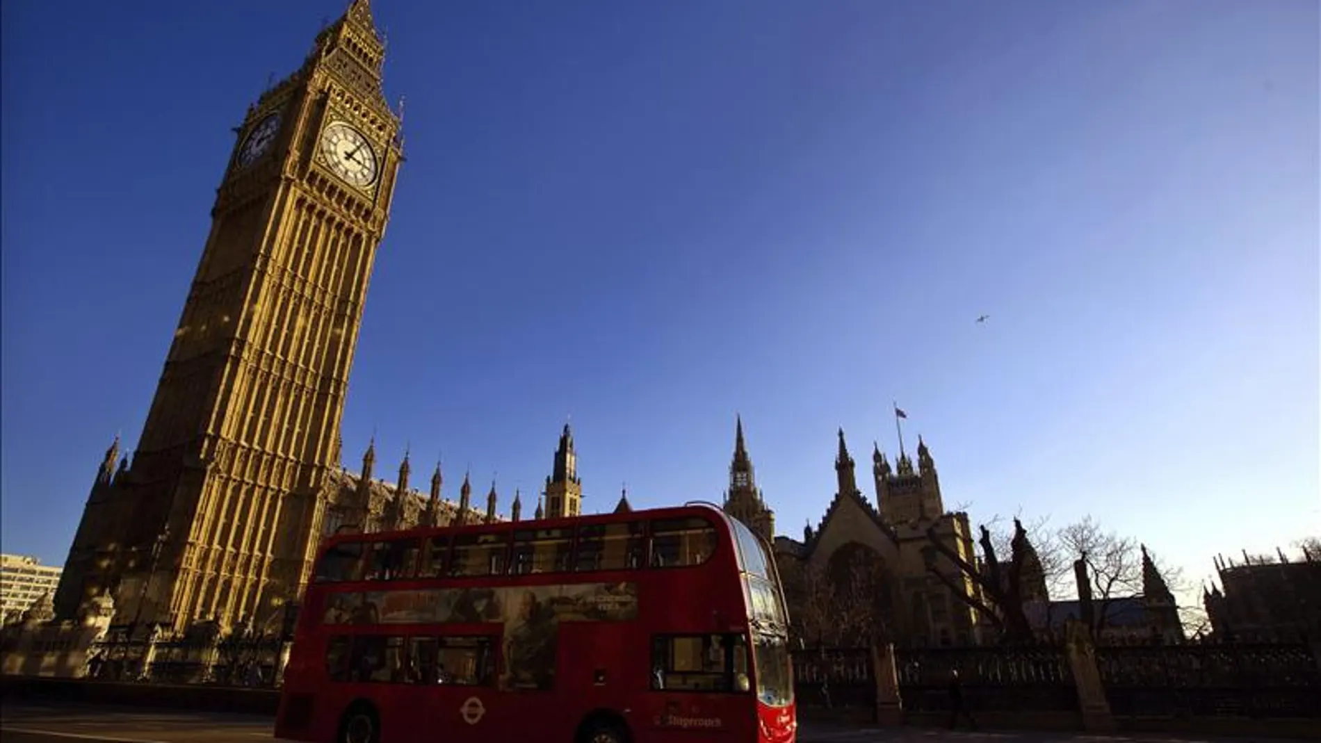 Un típico autobús inglés pasa por delante del Big Ben Un típico autobús inglés pasa por delante del Big Ben