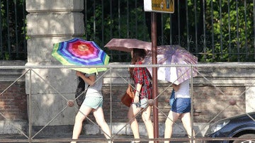 Jóvenes portan paraguas para evitar los rayos del sol