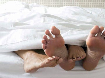 Pies de una pareja en una cama