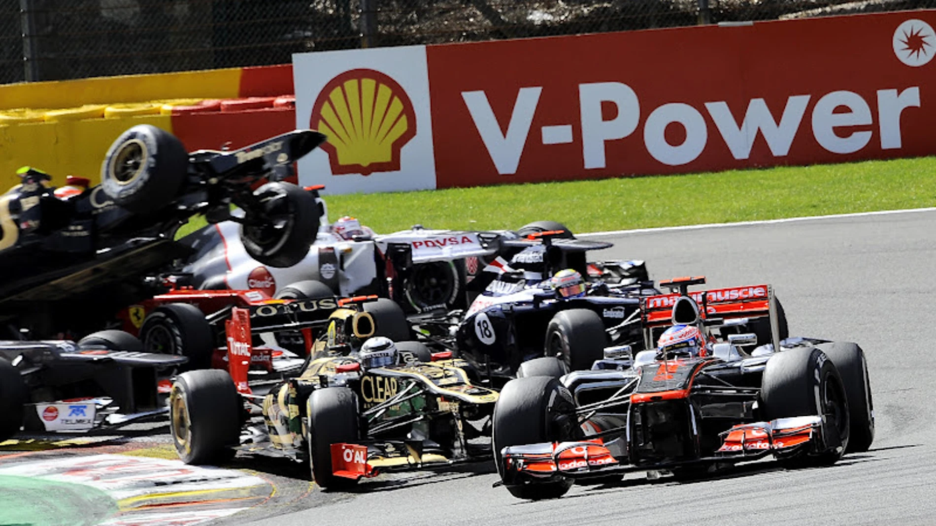 Grosjean pasa por encima de Alonso en la primera curva de Spa