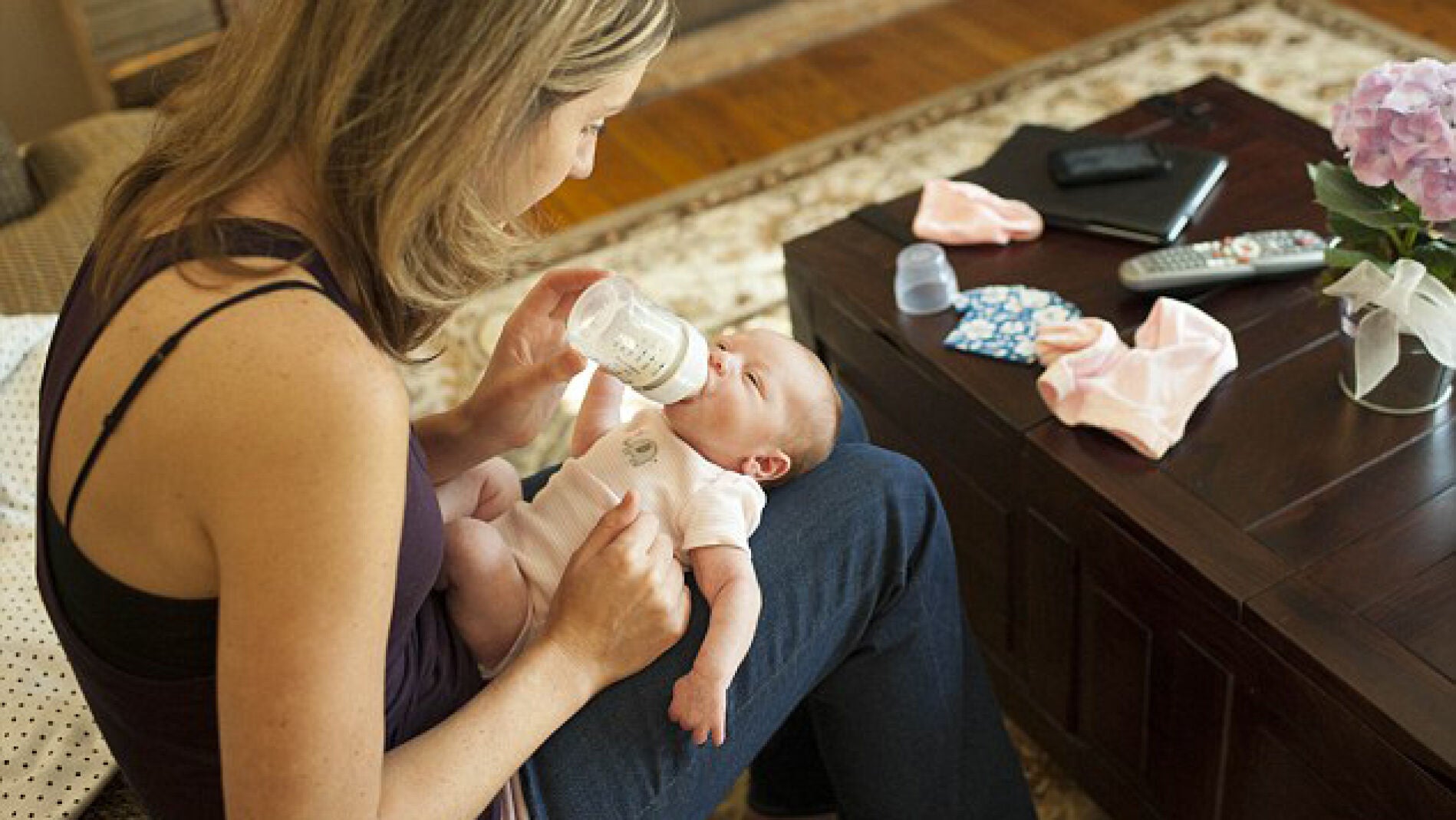 Una madre da el biber&oacute;n a su hijo