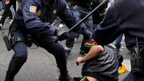 La Polic&iacute;a carga contra un manifestante al que retiene en el suelo