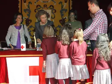 La reina con unas escolares en la mesa de cuestación instalada junto al Congreso de los Diputados La reina con unas escolares en la mesa de cuestación instalada junto al Congreso de los Diputados
