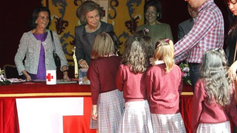 La reina con unas escolares en la mesa de cuestaci&oacute;n instalada junto al Congreso de los Diputados