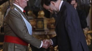 El rey Juan Carlos saluda al presidente Mariano Rajoy en la recepción en el Palacio Real