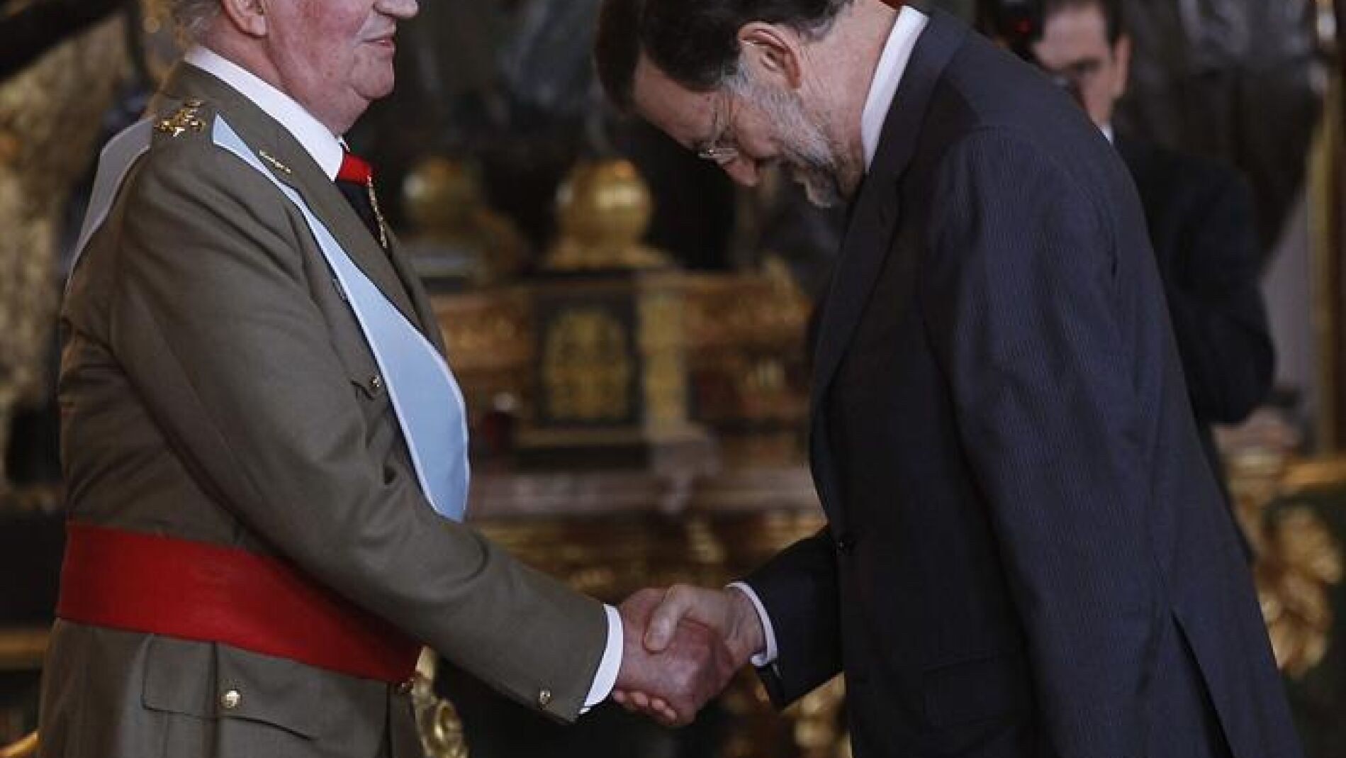 El rey Juan Carlos saluda al presidente Mariano Rajoy en la recepci&oacute;n en el Palacio Real