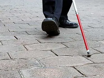 Un invidente camina con su bastón Un invidente camina con su bastón