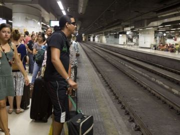 Los viajeros esperan la llegada de un tren