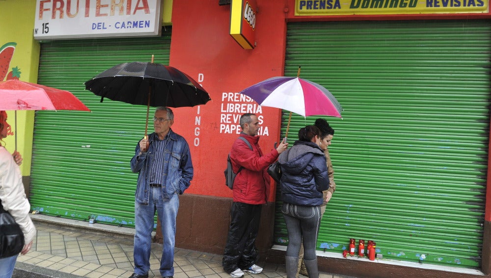 Vecinos del hombre que se ha suicidado colocan velas en su local