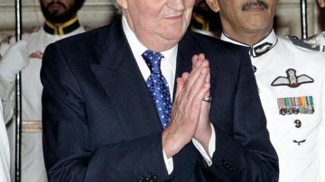 El rey de España, don Juan Carlos, saluda a un invitado antes de la cena que el presidente indio, Pranab Mujerjee