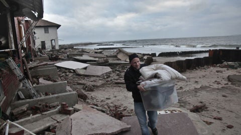 Un hombre recoge sus pertenencias tras el paso de Sandy