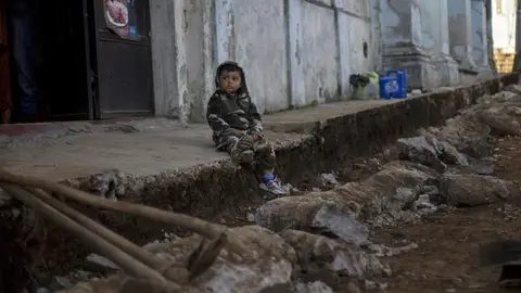 Un niño espera sentado entre los escombros en Guatemala Un niño espera sentado entre los escombros en Guatemala