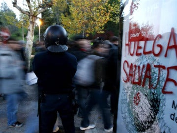 Un policía vigila a los manifestantes Un policía vigila a los manifestantes