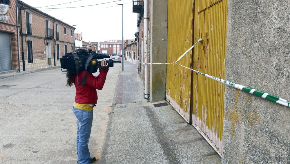 Una cámara de televisión graba la puerta de la nave industrial de Matapozuelos (Valladolid) donde estaba secuestrado el director de banco