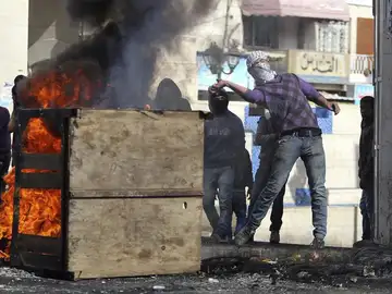 Unos palestinos lanzan piedras a los soldados israelíes en el Hebrón, Cisjordania Unos palestinos lanzan piedras a los soldados israelíes en el Hebrón, Cisjordania
