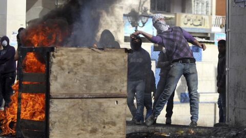 Unos palestinos lanzan piedras a los soldados israel&iacute;es en el Hebr&oacute;n, Cisjordania