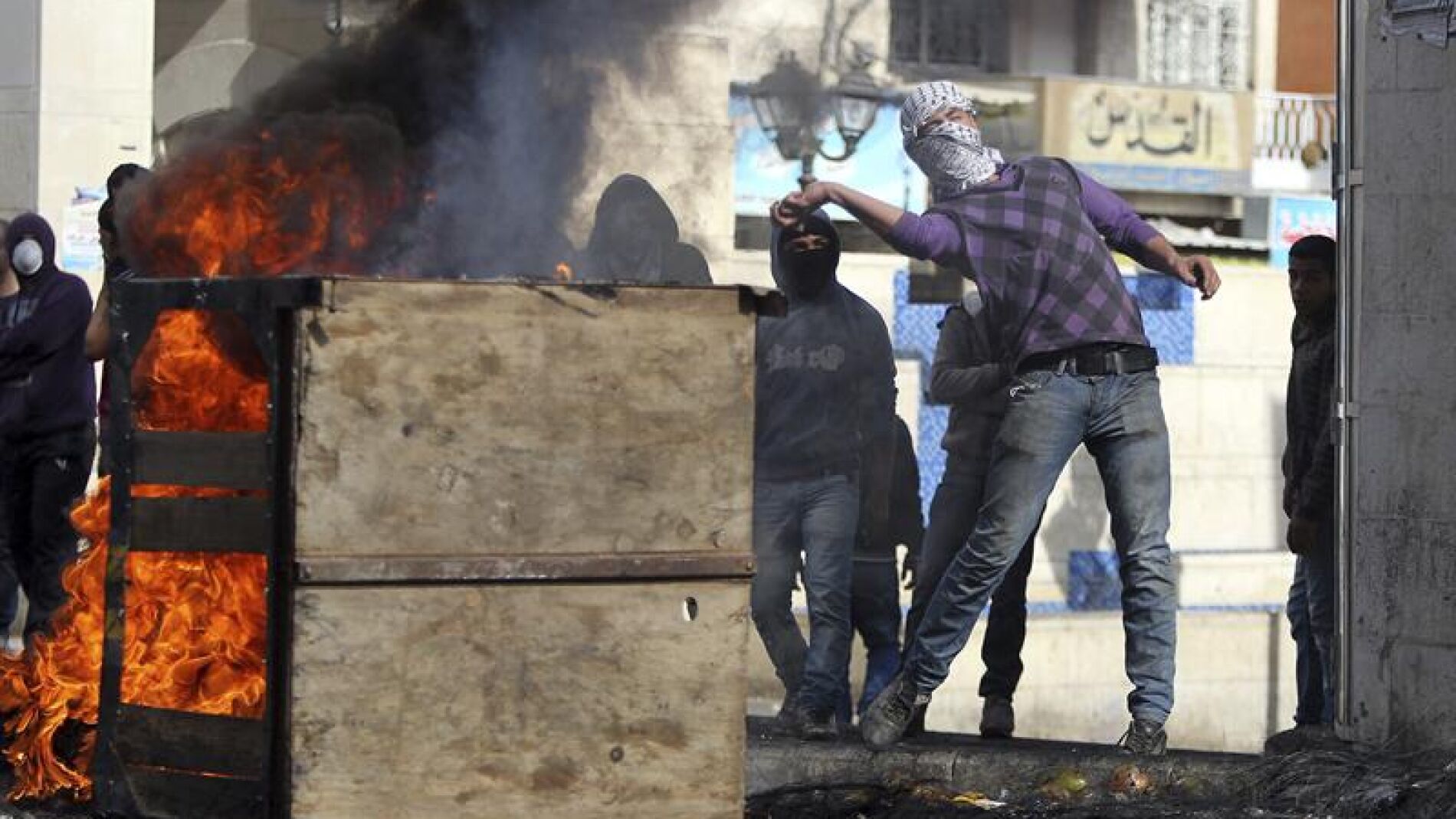 Unos palestinos lanzan piedras a los soldados israel&iacute;es en el Hebr&oacute;n, Cisjordania