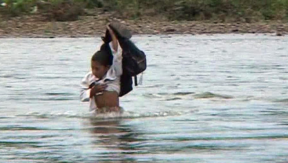 Un niño cruza el río Surati en Sumatra (Indonesia)