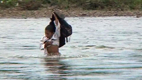Un ni&ntilde;o cruza el r&iacute;o Surati en Sumatra (Indonesia)