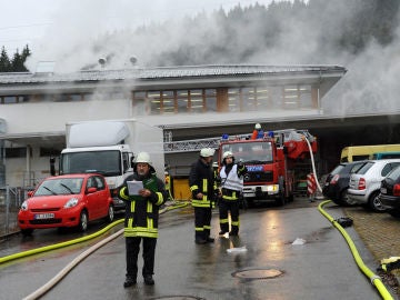 Un grupo de bomberos tratan de apagar un incendio en un taller de discapacitados