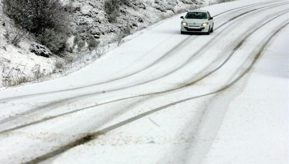 Un vehículo circula por el puerto de San Isidro (León) durante la nevada registrada en la región