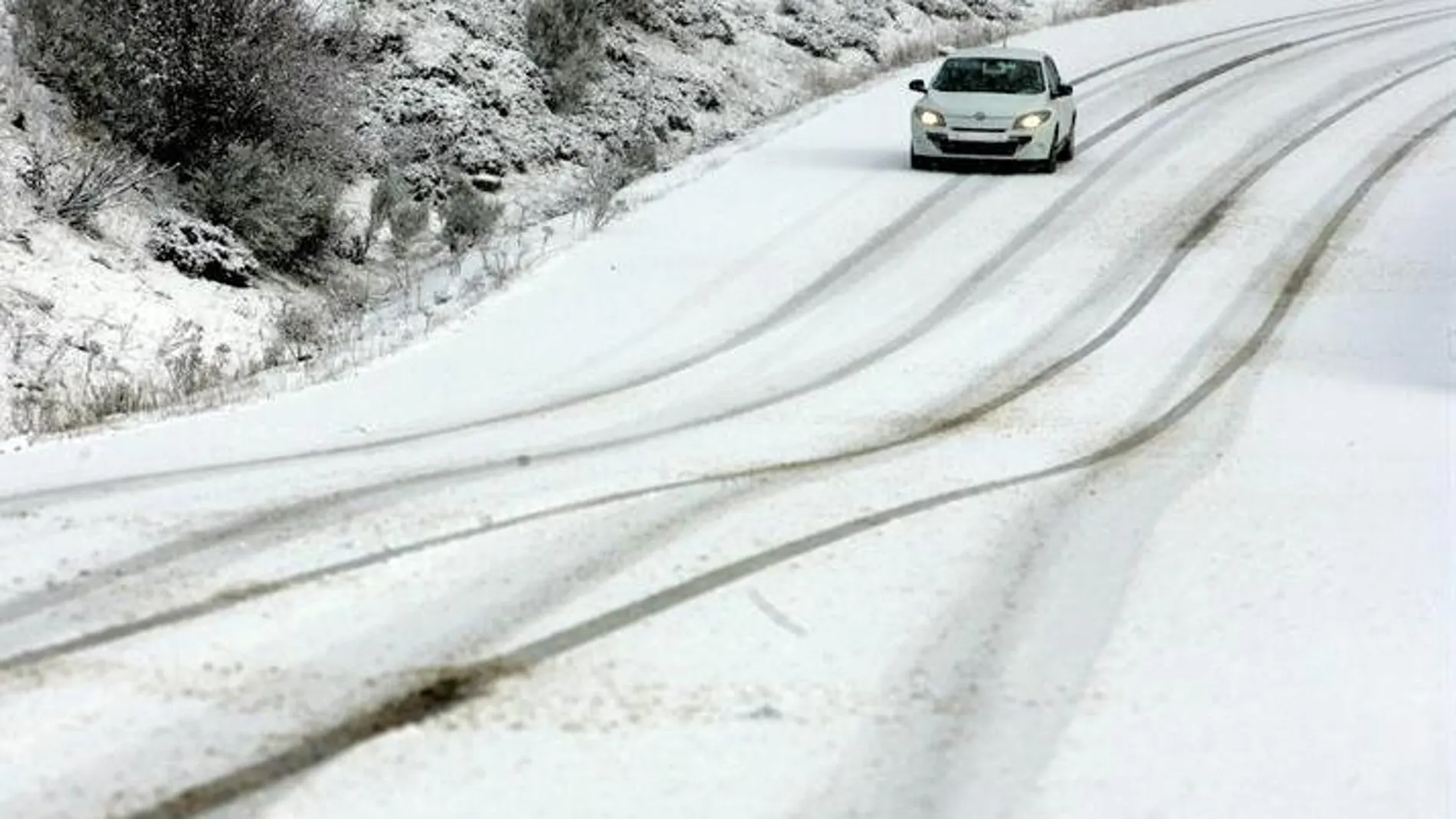 Un vehículo circula por el puerto de San Isidro (León) durante la nevada registrada en la región Un vehículo circula por el puerto de San Isidro (León) durante la nevada registrada en la región