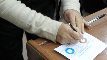 Una mujer rellena una papeleta de voto