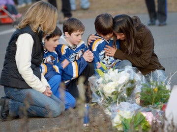 Tres niños lloran tras la masacre de Newtown
