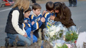 Tres niños lloran tras la masacre de Newtown