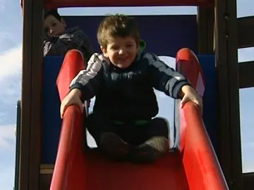 Un niño se tira por un tobogán Un niño se tira por un tobogán