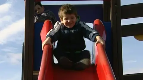 Un niño se tira por un tobogán Un niño se tira por un tobogán