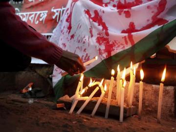 Una manifestante enciende una vela durante una protesta en contra de la salvaje violación de la joven