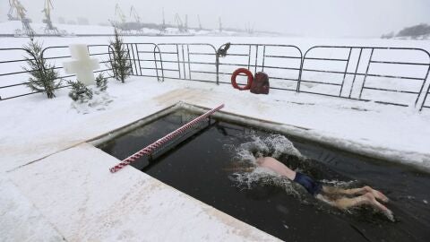 Un hombre nada en agua helada durante la celebraci&oacute;n de la epifan&iacute;a ortodoxa en Mosc&uacute;