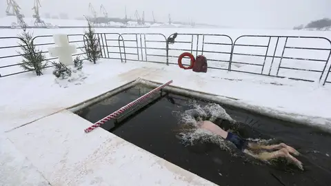 Un hombre nada en agua helada durante la celebración de la epifanía ortodoxa en Moscú Un hombre nada en agua helada durante la celebración de la epifanía ortodoxa en Moscú