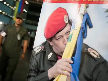 Un soldado camina cerca de un afiche del presidente de Venezuela Un soldado camina cerca de un afiche del presidente de Venezuela