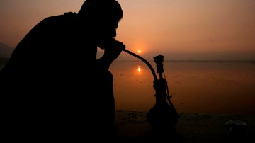 Un hombre fumando una pipa de agua