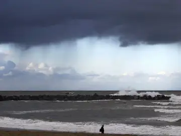 Un hombre camina por la playa de la Zurriola de San Sebastián Un hombre camina por la playa de la Zurriola de San Sebastián