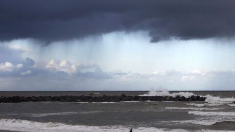 Un hombre camina por la playa de la Zurriola de San Sebasti&aacute;n