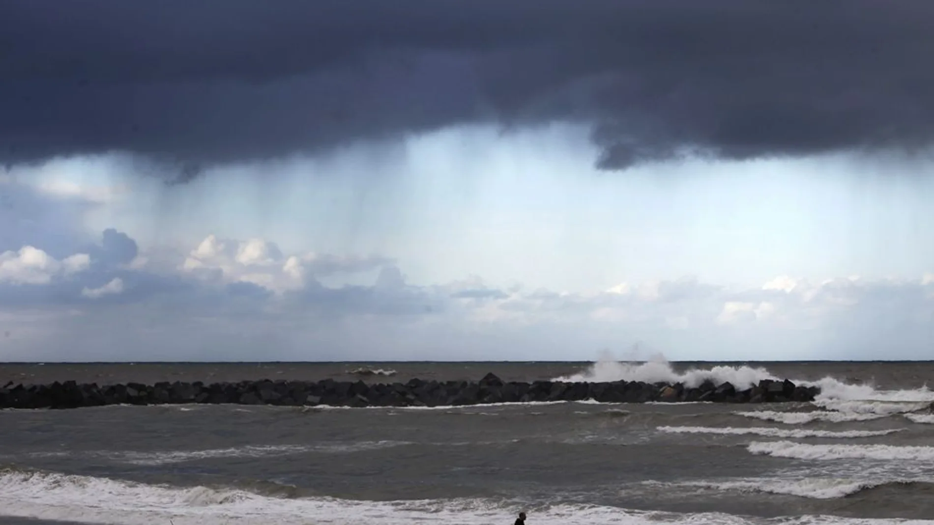 Un hombre camina por la playa de la Zurriola de San Sebastián Un hombre camina por la playa de la Zurriola de San Sebastián