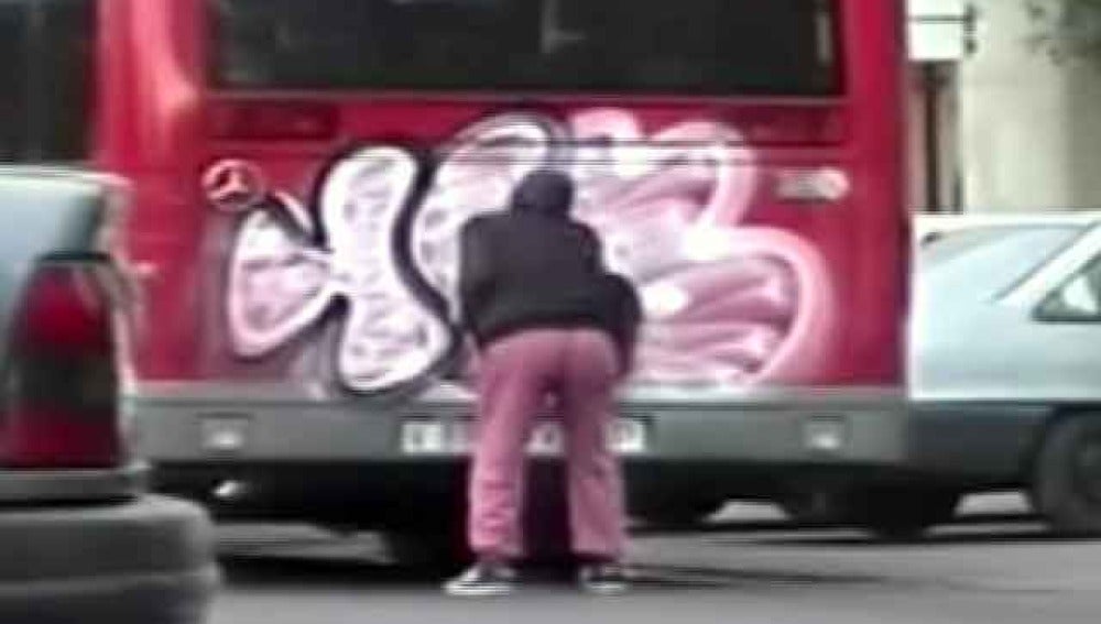 Graffitero pintando un autobus